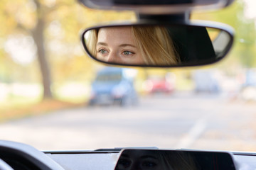 Eyes of a female driver in the rear view mirror
