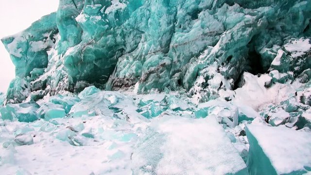Glacier of beautiful unique turquoise color on background of snow in Arctic. Amazing ice desert landscape. Silence quiet of wilderness North Pole Way to Pyramid on Spitsbergen Svalbard in Norway.