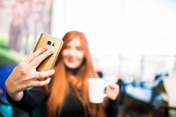 Beautiful girl drinking coffee at the coffee shop