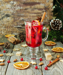 glass of hot mulled wine for the new year with ingredients for cooking, nuts and Christmas...