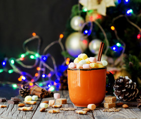 a cup of Christmas hot cocoa with marshmallow New Year's lights and decorations, selective focus