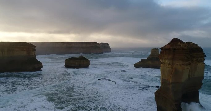 Limestone rocks off Australian coast along Great ocean road at sunrise. Slow panning towards apostle rock stone.
