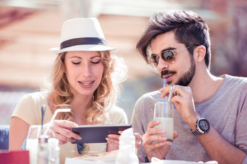 Young couple having fun and looking at the tablet.