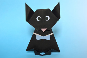 Origami black cat on blue background