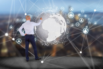 Businessman in front of a wall with International network displayed on a futuristic interface with globe and connection - technology and business concept
