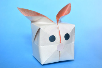Origami balloon rabbit on blue background