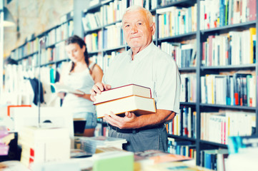 Mature man is showing book that he bought