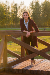 beautiful girl on a wooden bridge at sunset