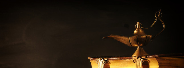 Image of magical aladdin lamp and old books. Lamp of wishes.