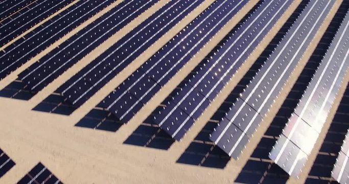 Aerial view flying over large solar farm in desert creating clean renewable energy 