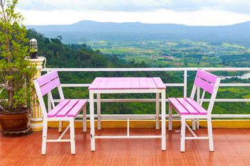 Magnificent outdoor terrace with pink chairs table on marble terrace with mountain view and decoration in contemporary home.