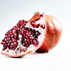 Two pomegrantes on a white  background.