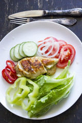 A fresh meal of chicken fillet with vegetables and tasty juice on a dark wooden background