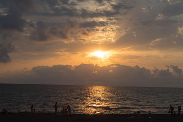 Obraz premium Beautiful summer golden sunset above the black sea.with calm waves and reflection of sun on the beach