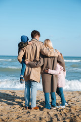 family hugging on seashore