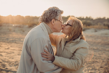senior couple kissing on beach
