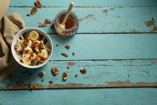 Fruit cereal and honey on a wooden table