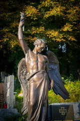 Obraz premium gray gravestone surrounded by greenery and warm sunshine shining from behind the trees