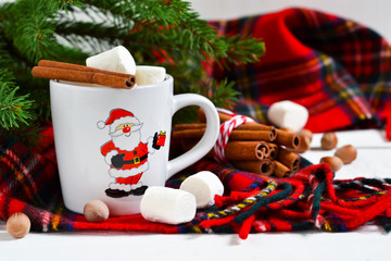 A cup of hot winter drink with marshmallow and cinnamon. New Year's background.