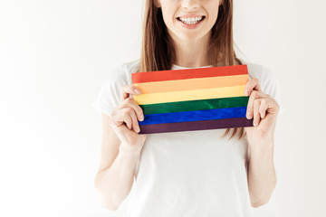 woman holding small rainbow flag