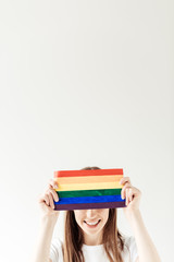 woman covering forehead with rainbow flag