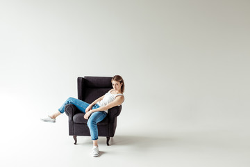 woman in singlet sitting on armchair