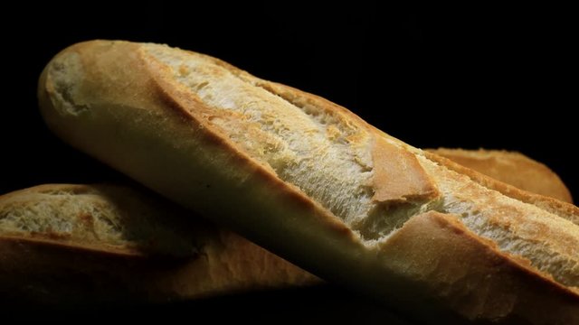 Freshly baked bread rotates against black background