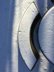 View from above of a snow-covered, concrete picnic bench and table.