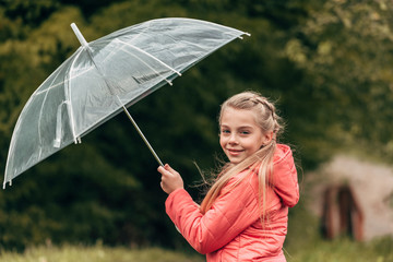 child with umbrella in autumn park