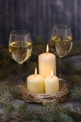Candles and two glasses wine on background