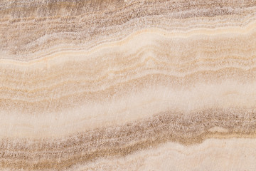 Obraz na płótnie Canvas Lightened slices marble onyx. Horizontal image. Warm calm colors. Beautiful close up background, onyx marble texture.