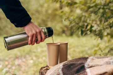 man pouring tea from thermos