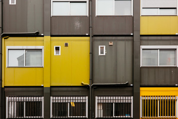 A flat view of the wall of a building full of compact apartments.