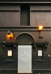 Floodlights on the wall of a dilapidated building point in different directions.