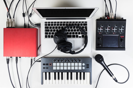 Portable and compact music home studio for electronic and beat music production. Top view of modern music recording set up with professional headphones, software controllers, digital effect processors