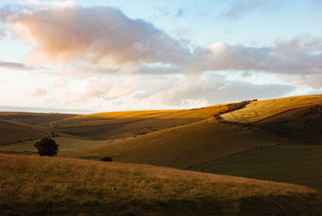 Fototapeta na wymiar An ending sunset creates a colourful sky and textured valley in South Downs, England.