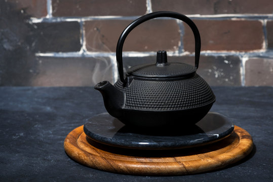 black cast iron kettle on a dark background