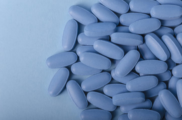 blue drug tablets over a light background for medical uses.