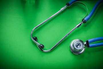 Medical auscultator on green background