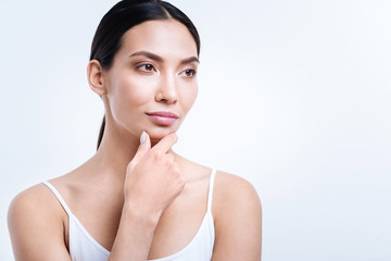 Dark-haired young woman resting her chin on fingers