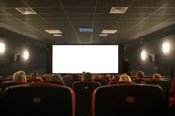 Empty cinema seats with blank white screen - obrazy, fototapety, plakaty