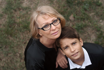 Good-looking, single-parent mom and teen son in the park. Photo top view. Cohesion, friendship and family relations.