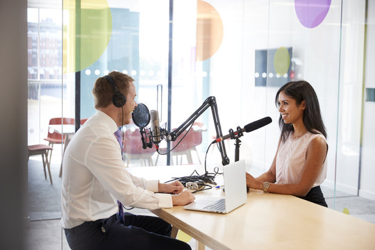 Young man interviewing a woman in a radio studio