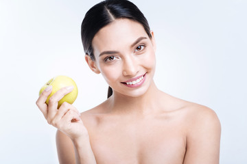 Obraz na płótnie Canvas Cheerful woman holding yellow apple