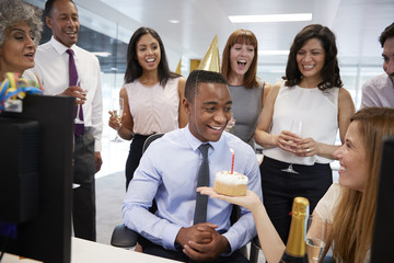 Colleagues gathered at a man’s desk to celebrate a birthday