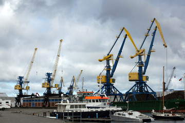 Fototapeta na wymiar Blue and yellow port cargo cranes in the harbour