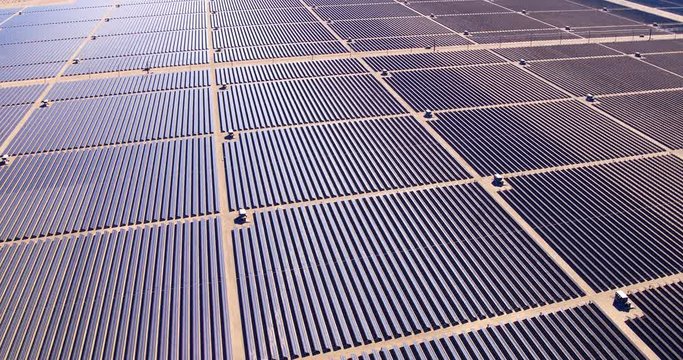 Aerial View Flying Over Large Industrial Solar Energy Farm In Desert 