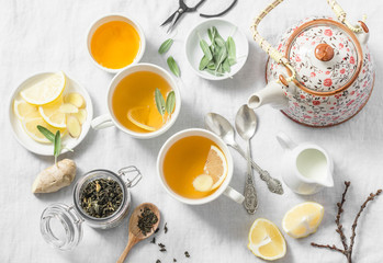 Obraz na płótnie Canvas Green tea with lemon, ginger, sage on a light background, top view. Healthy detox drink. Tea ceremony