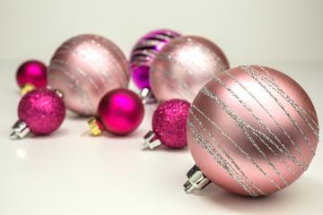 christmas baubles in different shades of pink with silver glitter