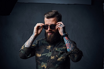 Portrait of bearded tattooed hipster male dressed in a military 